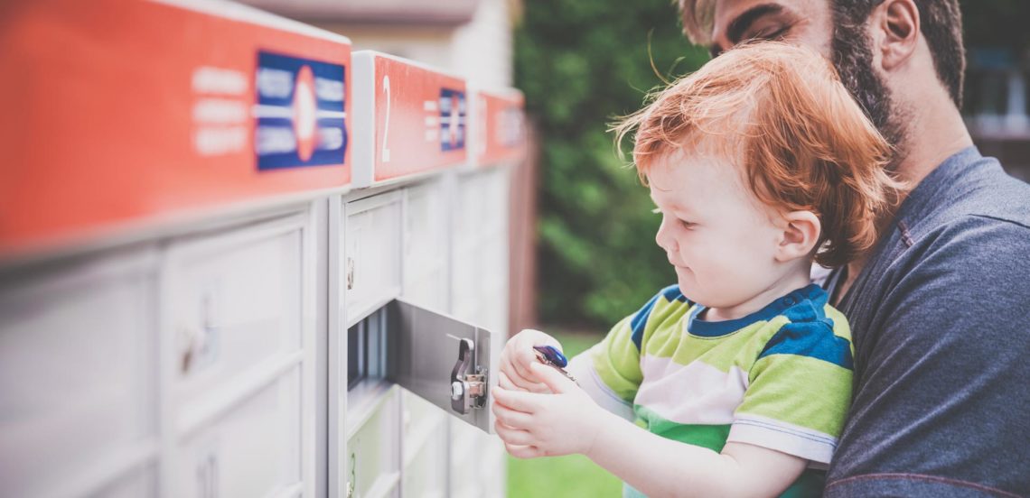 Baby boy opening a mailbox with parent